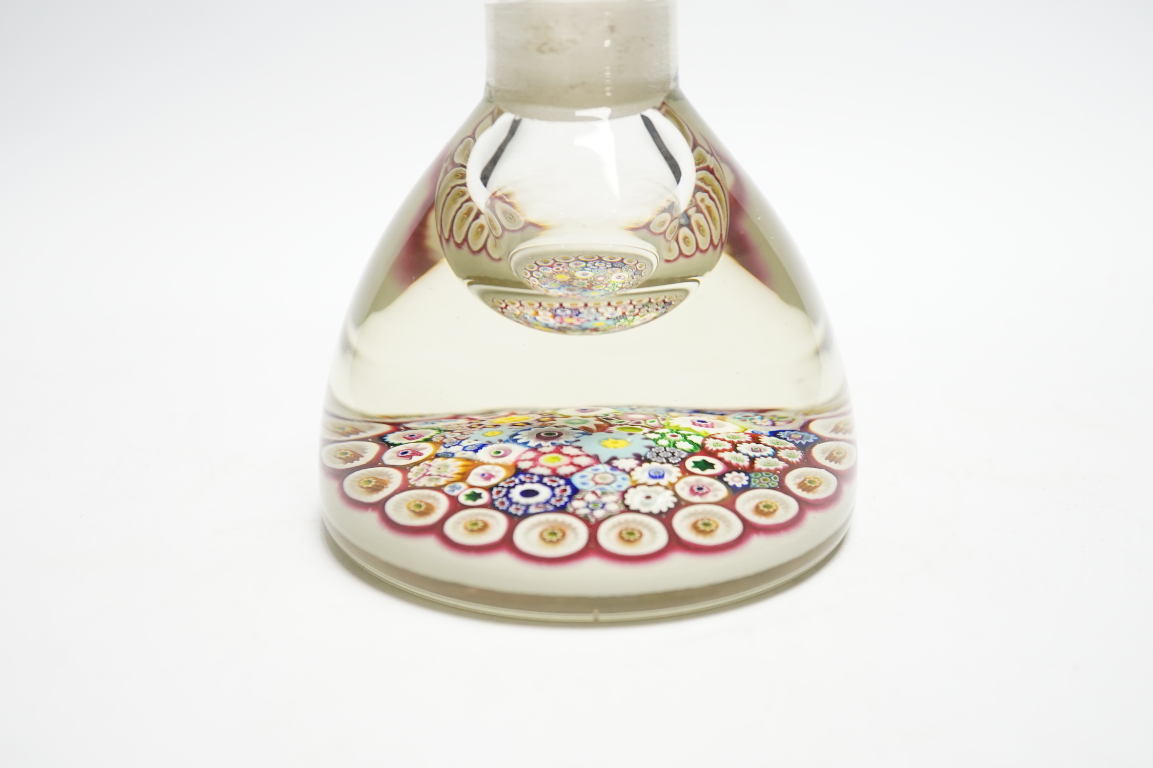 A Paul Ysart close packed millefiori glass inkwell or bottle and stopper, Caithness period, scratched signature ’P. Ysart’ to underside, opaque white ground, 10cm diameter, 13.5cm high